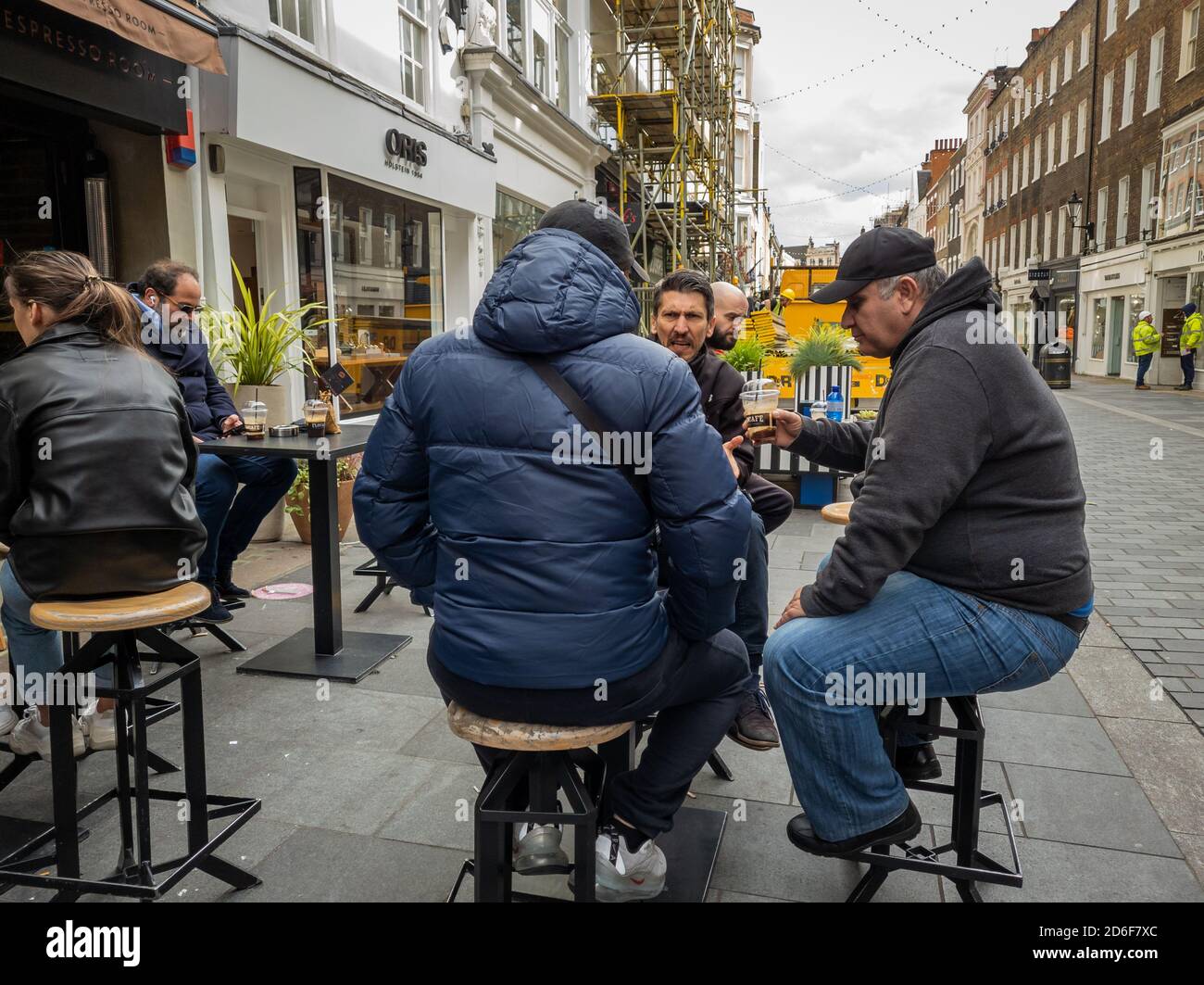 Menschen, die Kaffee genießen und sich vor einem Café unterhalten. Stockfoto