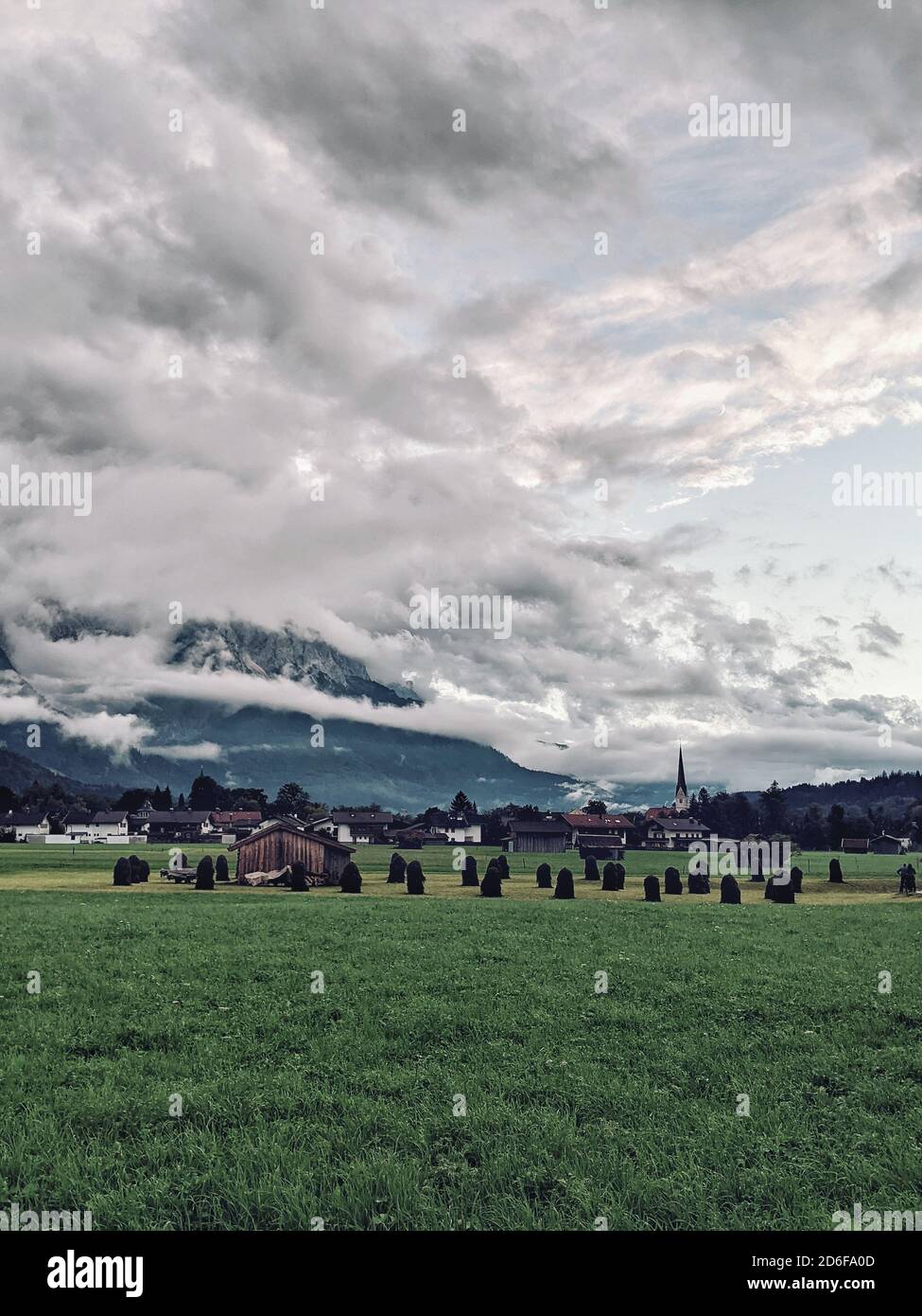 Wiese mit Heubergen, Wolken bedecken die Zugspitze, Garmisch-Partenkirchen Stockfoto