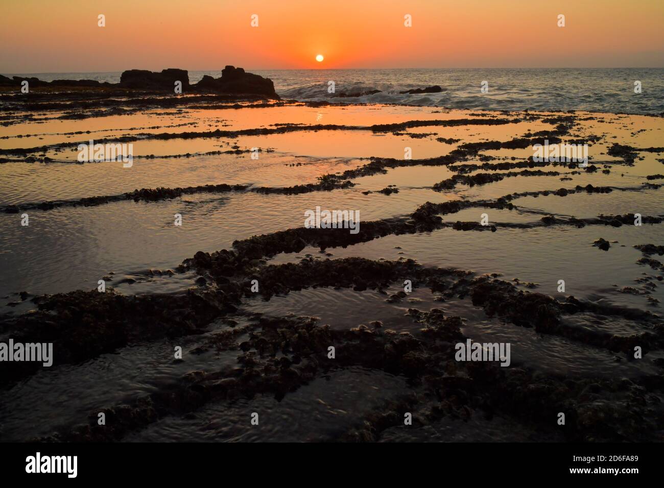 Sonnenaufgang mit Felsenpools am Strand Stockfoto