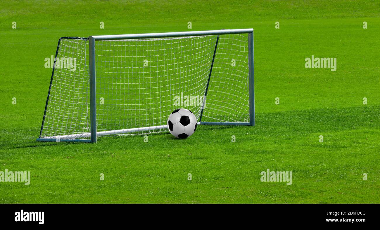 Fußballtor mit Ball auf einem Fußballfeld Stockfoto