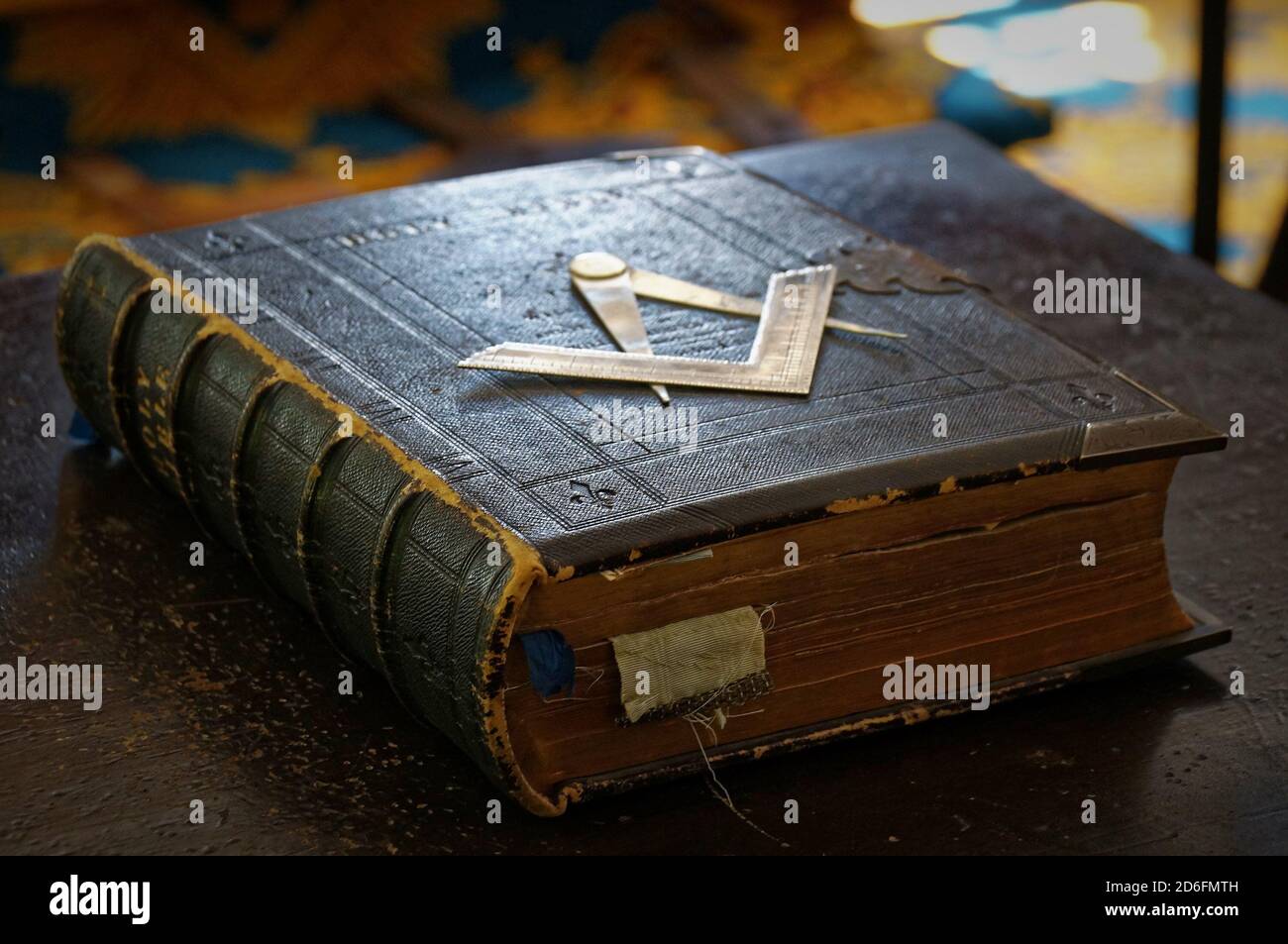Alte Freimaurer Bibel Buch mit abgedunkelten Seiten und alt Lesezeichen in dunkelbraunem Ledereinband mit Quadrat und Kompass Metallisches Symbol auf dem Deckel Stockfoto