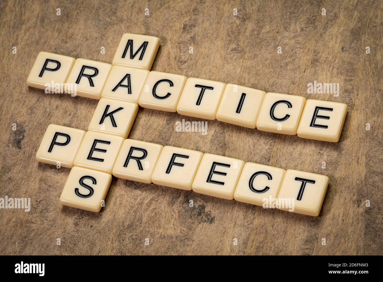 Praxis macht perfekte Kreuzworträtsel in Elfenbein Buchstaben gegen strukturierte Rinde Papier, Bildung und Ausbildung Konzept Stockfoto