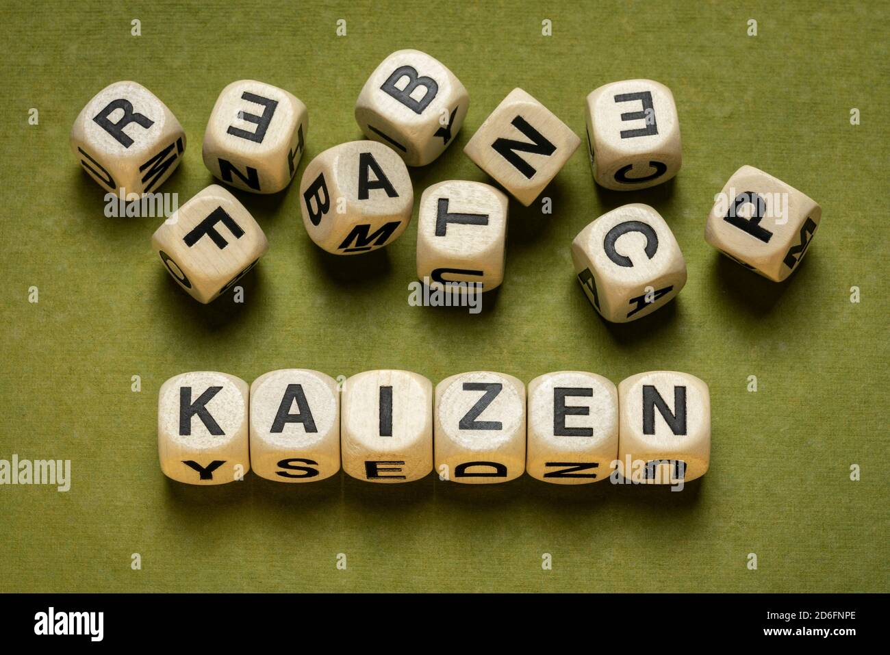 kaizen Wortabstrakt in Holzbuchstabenwürfeln gegen grünes handgemachtes Papier in Grüntönen, japanische kontinuierliche Verbesserung und eine Änderung für bessere Konz Stockfoto