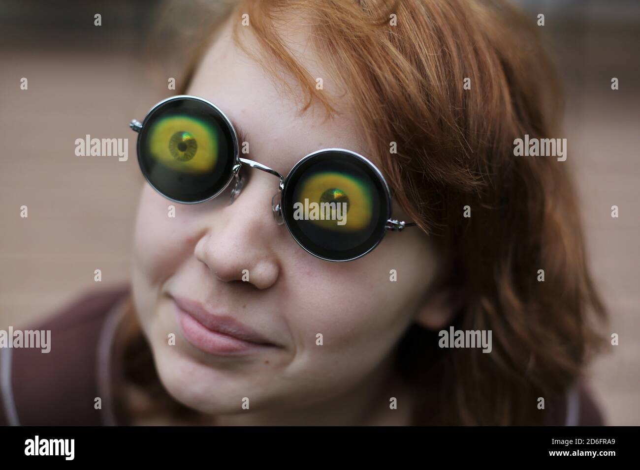 Ein Mädchen trägt eine Brille mit großen seltsamen Augäpfel. Stockfoto