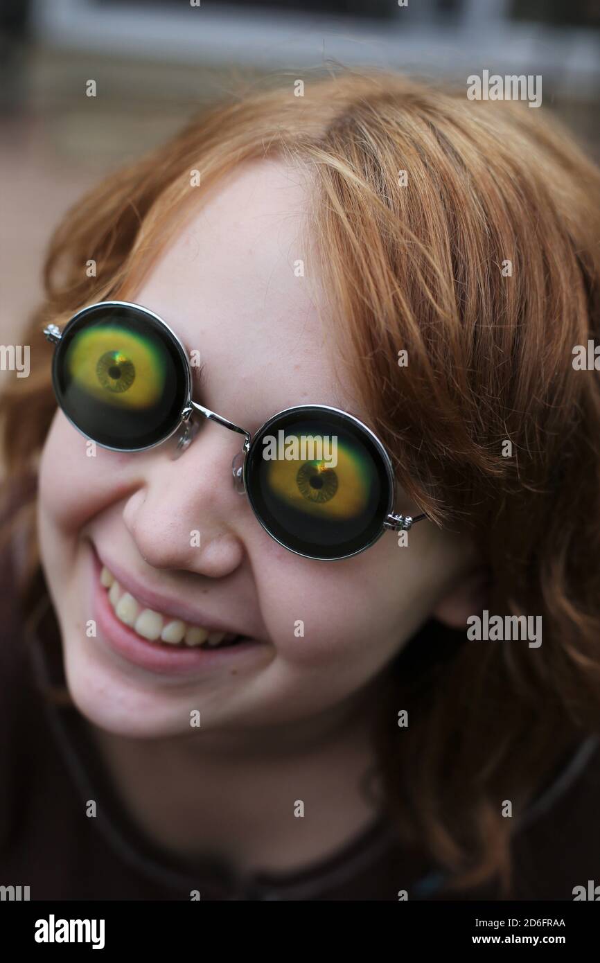 Ein Mädchen trägt eine Brille mit großen seltsamen Augäpfel. Stockfoto