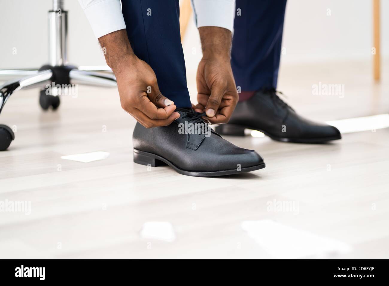 Afrikanisch Amerikanischer Mann, Der Schuhe Im Büro-Stockwerk Wechselt Stockfoto