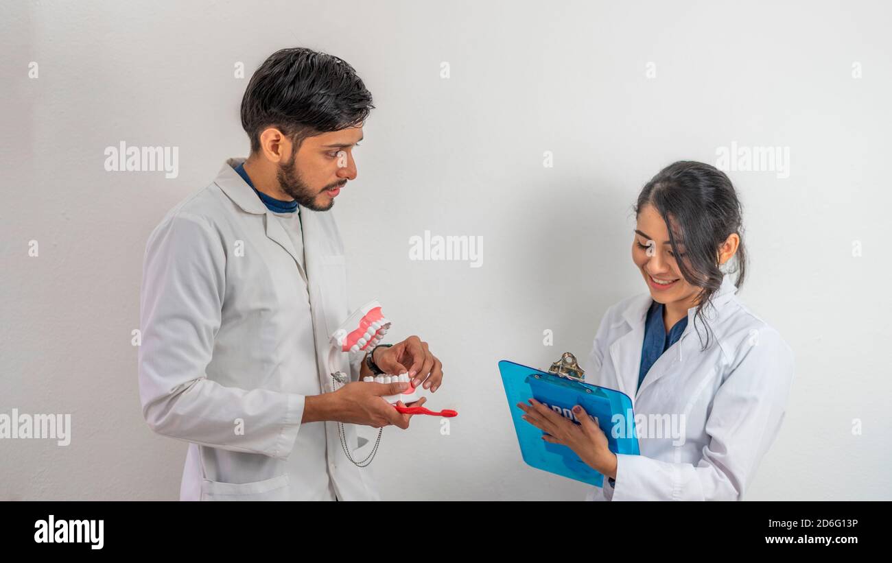 Junge hispanische Dentalhygieniker diskutieren ein Thema Stockfoto
