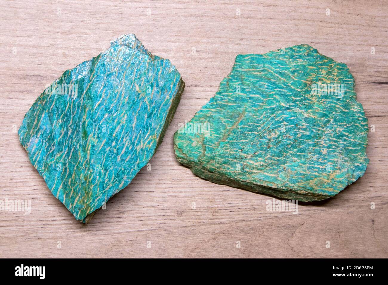 Zwei Stücke von schönen hellen semiprecious Mineral Amazonit liegen auf Eine hölzerne Oberfläche Stockfoto
