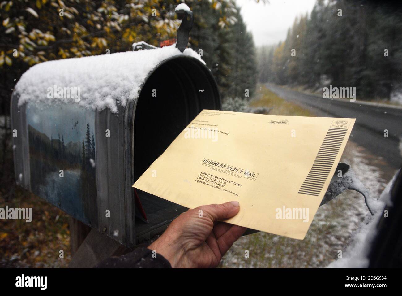 Ein Bewohner im ländlichen Lincoln County Montana legt einen Wahlgang 2020 in seinem Briefkasten vor der Wahl am 3. November 2020. Stockfoto