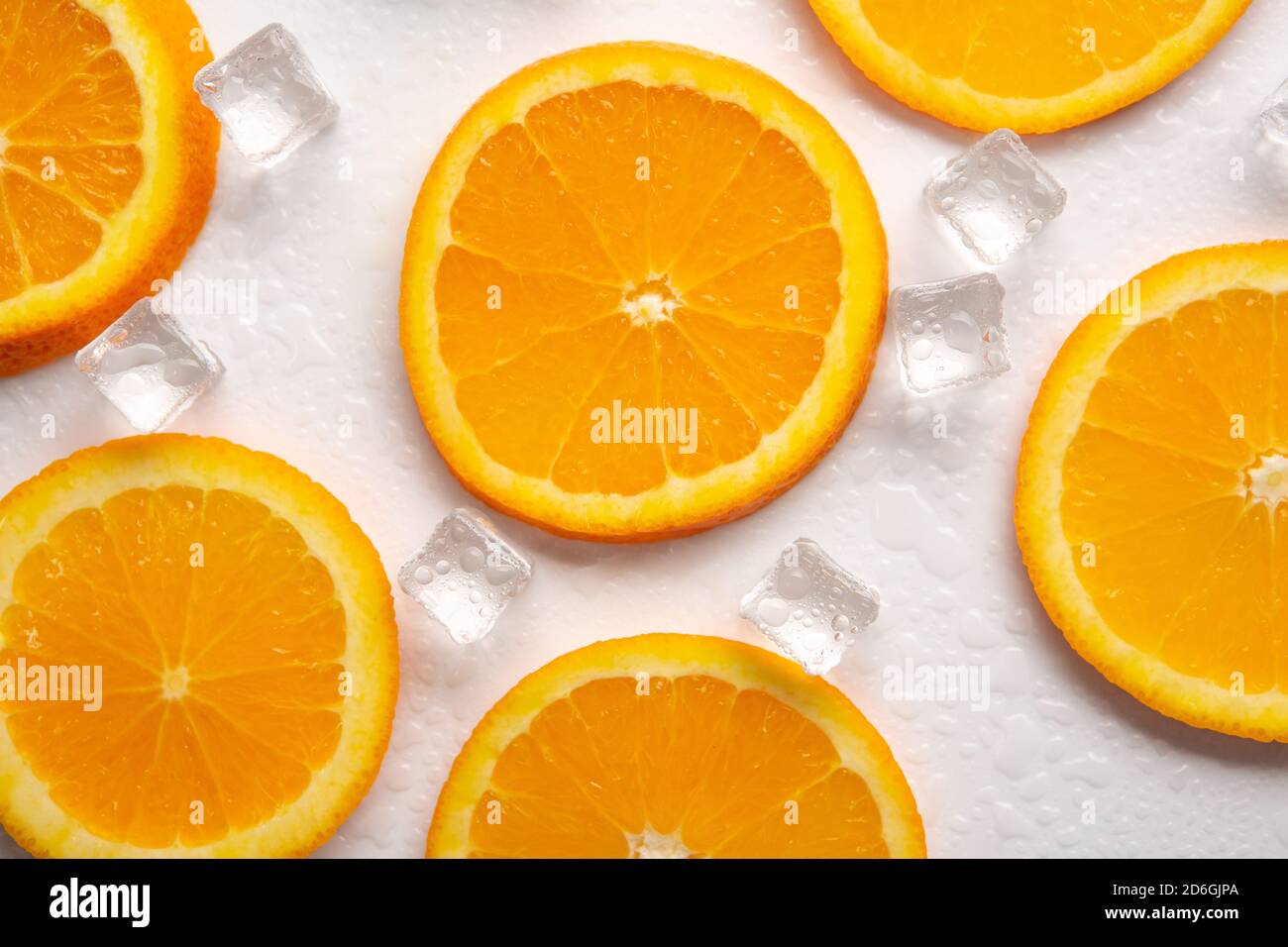 Orangenscheiben mit Eis auf weißem Hintergrund Stockfoto