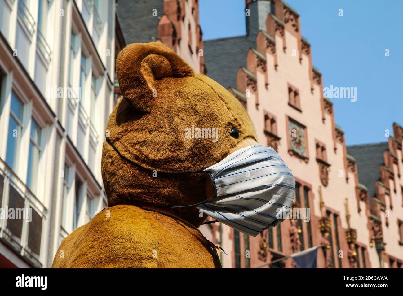 Das Detail des großen Plüsch Teddybären trägt eine Gesichtsmaske als Schutz gegen Corona-Virus. Stockfoto