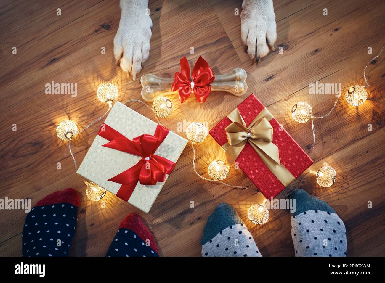 Feiertagsfeier zu Hause. Familie rund um weihnachtsgeschenke und Knochen für Hund. Stockfoto