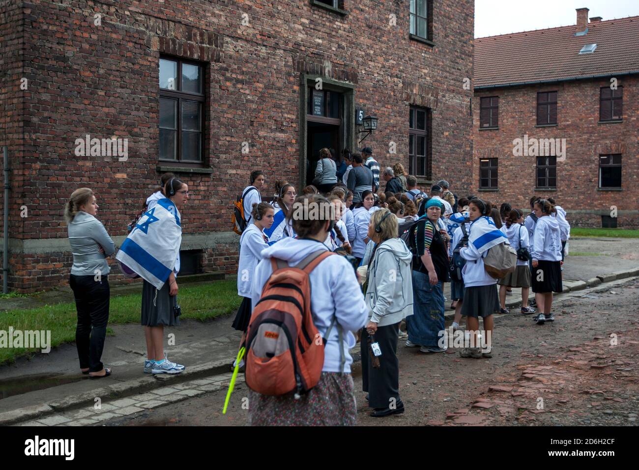 Israelische Besucher, die mit der Flagge Israels drapiert sind, betreten Gebäude Nr. 5 im Auschwitz-Birkenau Staatsmuseum in der Nähe von Oswiecim in Polen. Stockfoto