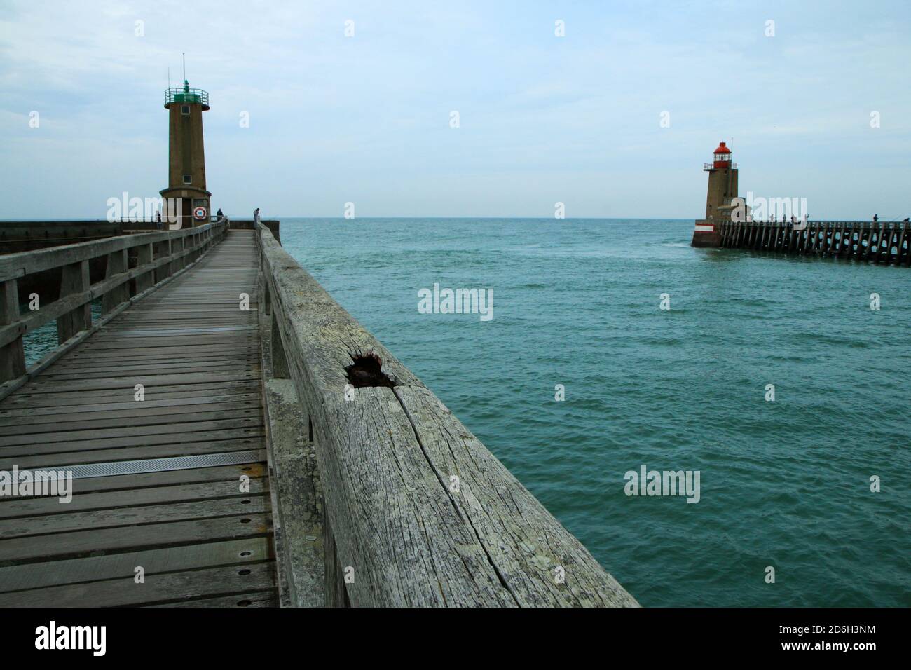 Die hölzernen Fußgängerbrücken über das Meerwasser führen zu den Leuchttürmen im Hafen der Stadt Fécamp in der Normandie in Frankreich. Stockfoto