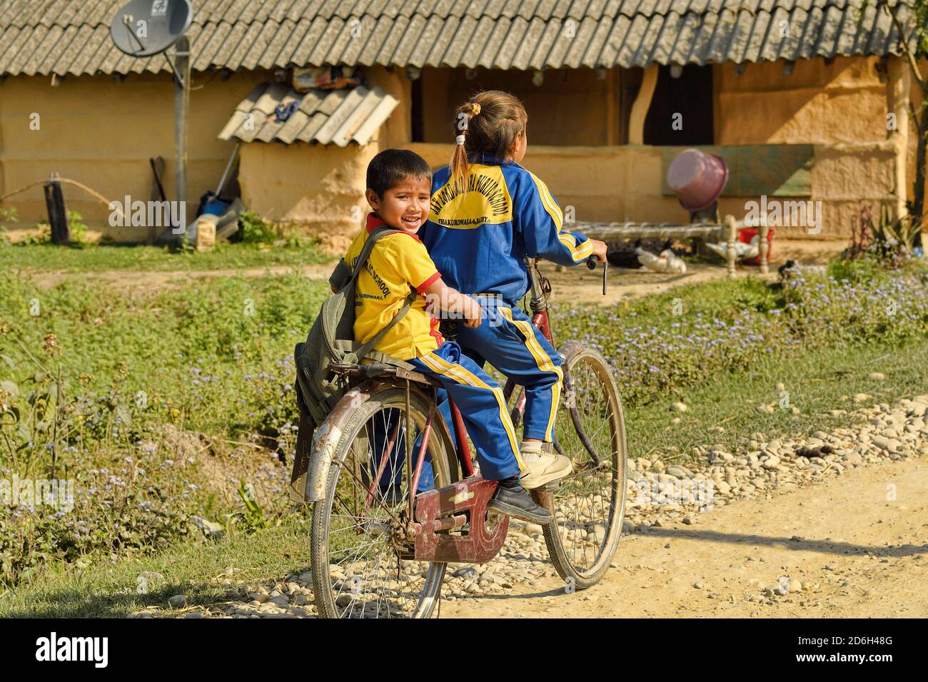 Kinder gehen mit dem Fahrrad in Thakadurwa, Terai, Nepal zur Schule. Stockfoto