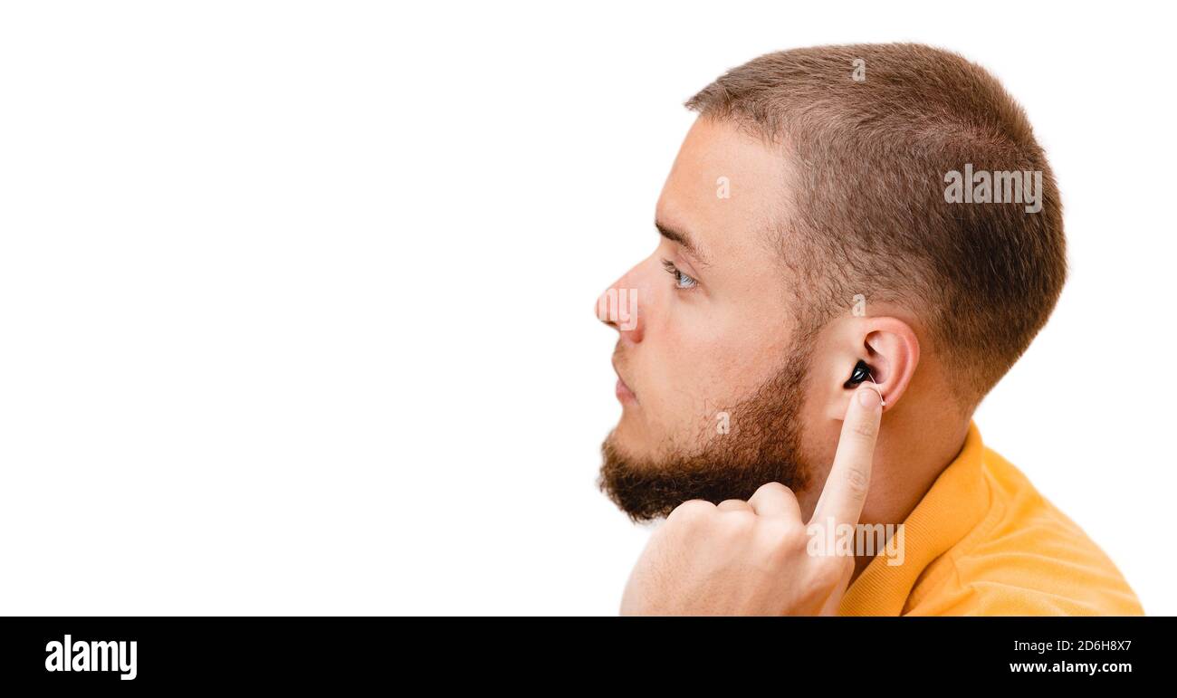 Mann, der ein Intra-Ohr-Hörgerät im Ohr zeigt, Nahaufnahme. Hörlösungen für Gehörlosigkeit Behandlung Stockfoto