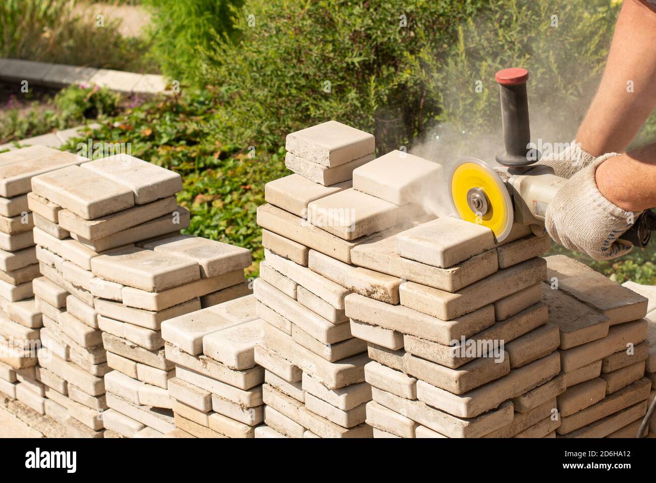 Master Sägen Pflaster Platten mit einem Schleifer Mühle. Staub. . Stockfoto