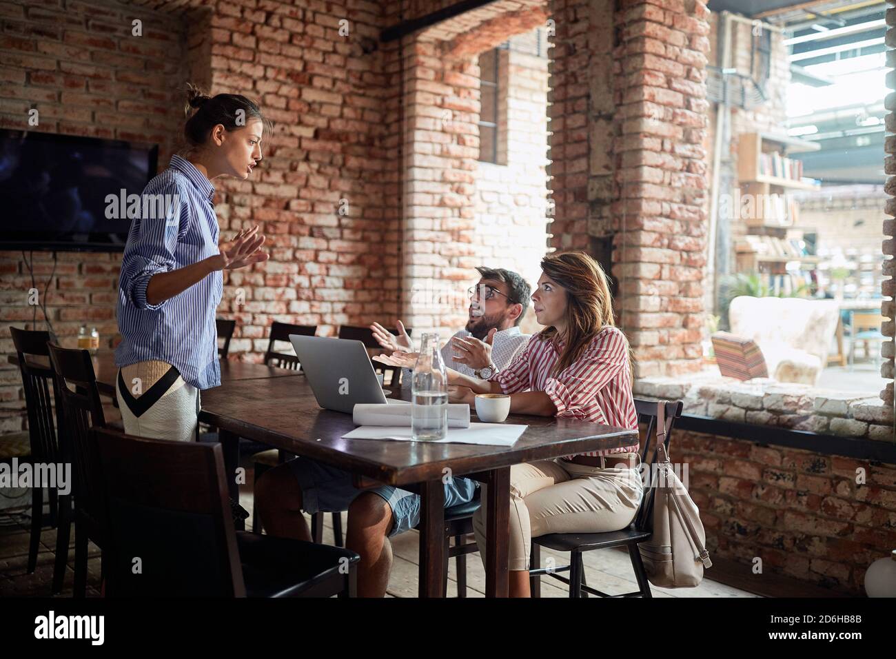 Kellnerin und junges Paar streiten sich über Lärm in einem Café Stockfoto
