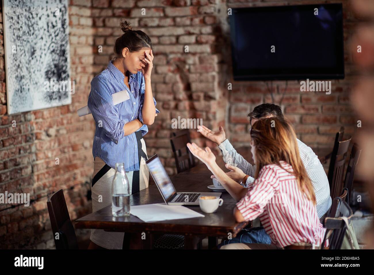 Junges Paar rechtfertigen sich vor wütender Kellnerin an Ein Café Stockfoto