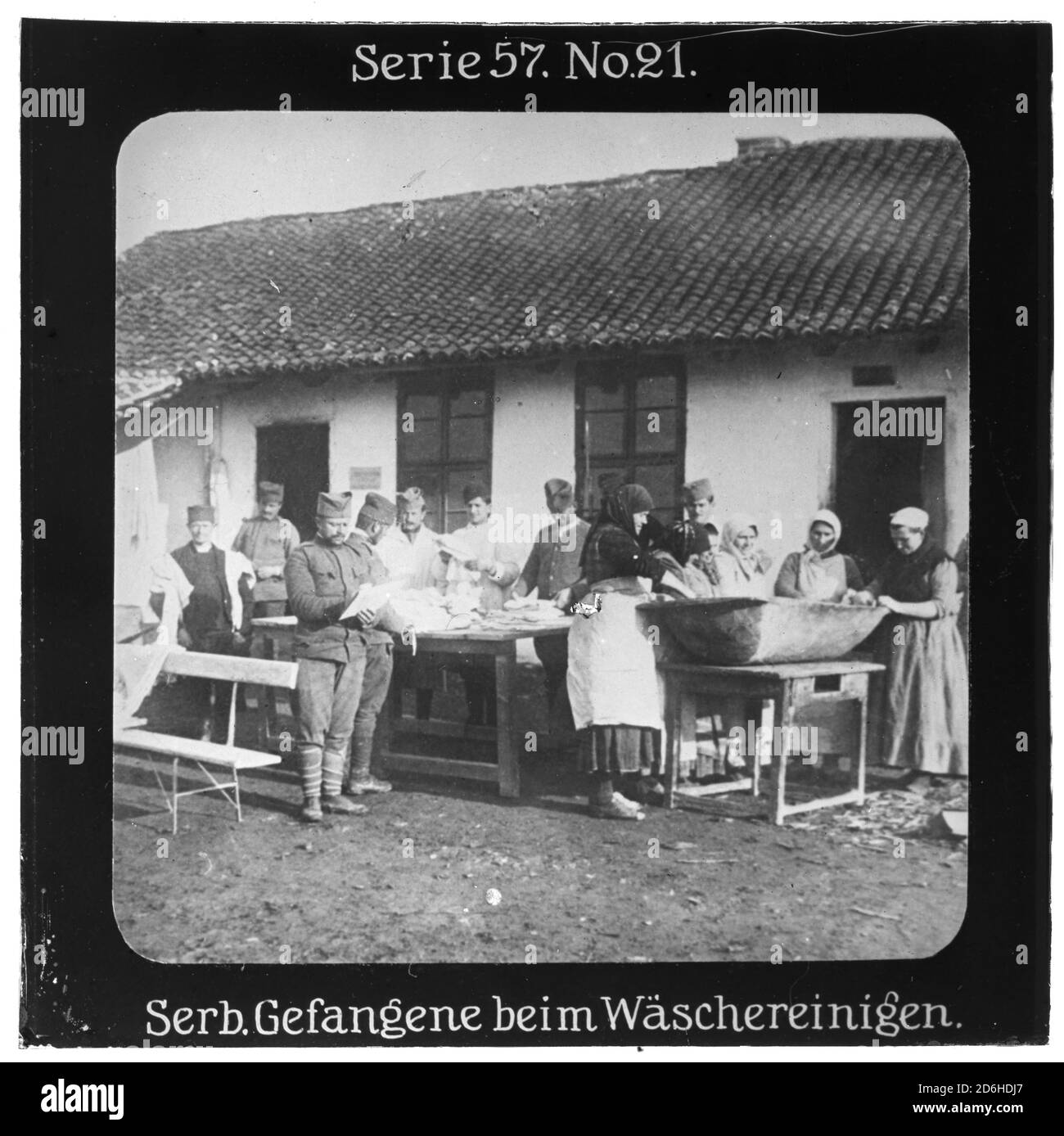 Projektion für alle - die Erobung Serbien. Serie 57. Nr. 21. Serbische Gefangene beim Wäschereinigen. Nach dem Scheitern des Serbienfeldzugs der k.u.k. Armee im Jahr 1914 wurde im Oktober 1915 mit massiver deutscher Unterstützung ein neuer Feldzug durchgeführt. Die Firma „Projection für alle“ wurde 1905 von Max Skladanowsky (1861-1939) gegründet. Sie producated bis 1928 fast 100 Serien zu je 24 Glasdias im Format 8,3 x 8,3 cm im sog. Bromsilber-Gelatin-Trockenplatten Verfahren. Die Serien umfasster Städte, Länder, Landschaften, Märchen und Sagen, das Alte Testament u. den 1. Weltkrieg. Stockfoto