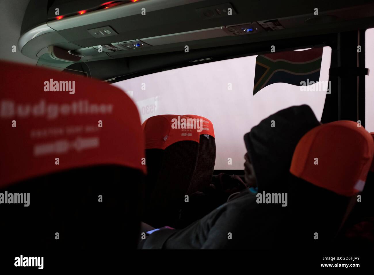 Passagiere, die während der Pandemie von Covid-19 in Südafrika in einem Bus (Reisebus) maskiert fahren. Stockfoto