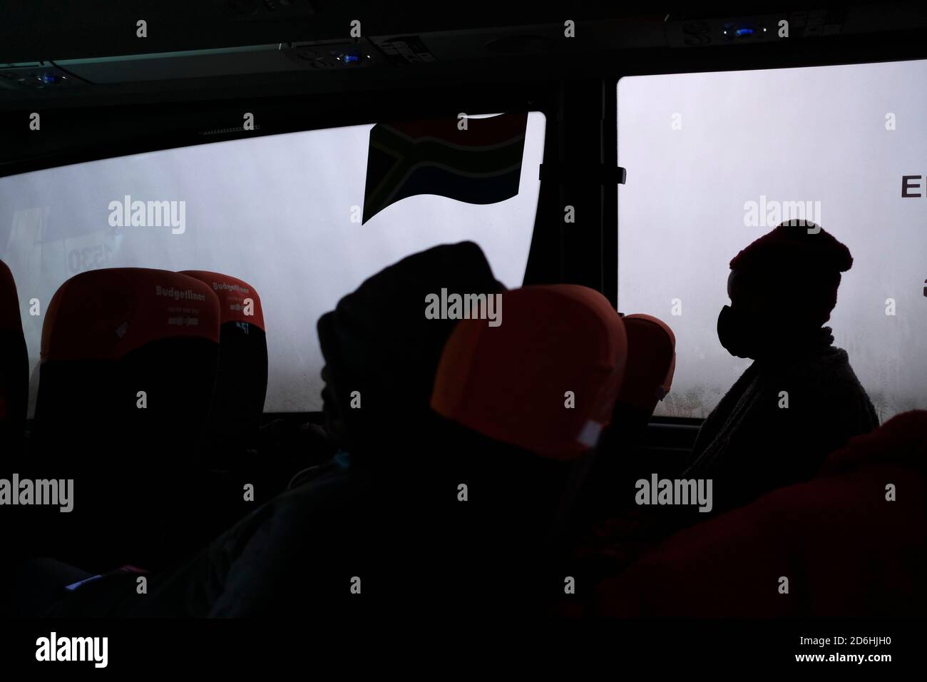 Passagiere, die während der Pandemie von Covid-19 in Südafrika in einem Bus (Reisebus) maskiert fahren. Stockfoto