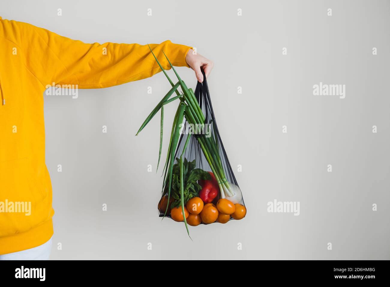 Nachhaltige Multi-Use-Beutel mit Bio-Gemüse. Frau Hand hält Lebensmittelbeutel mit Gemüse und Tomaten, Konzept der Bio-Lebensmittel einkaufen, na Stockfoto