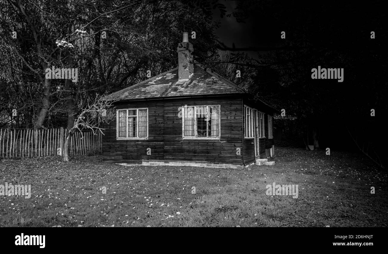 Kleiner Holzbungalow, der in einem Holz repariert werden muss. Stockfoto