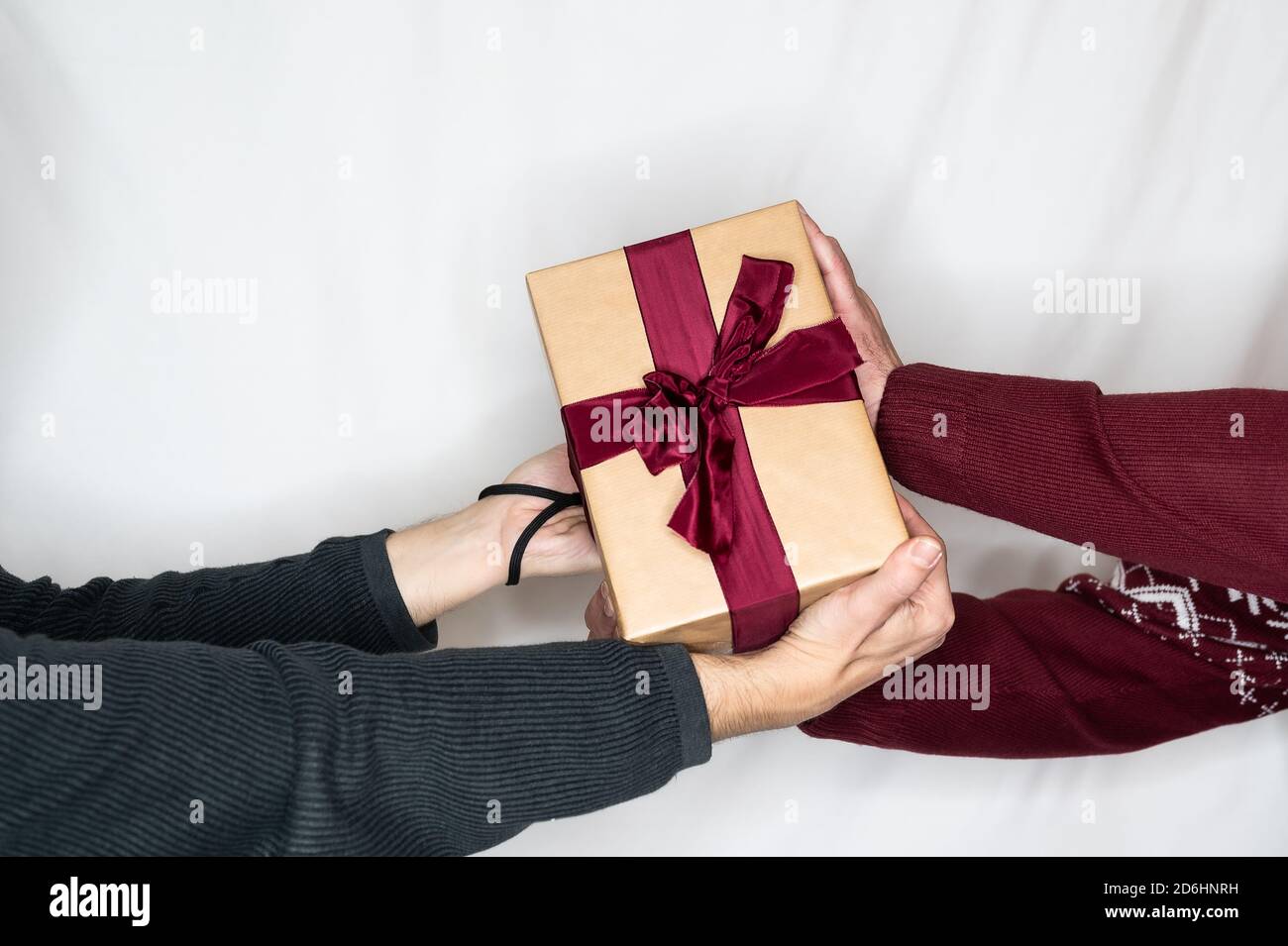 Zwei Menschen kämpfen um ein Geschenk mit rotem Band Stockfoto