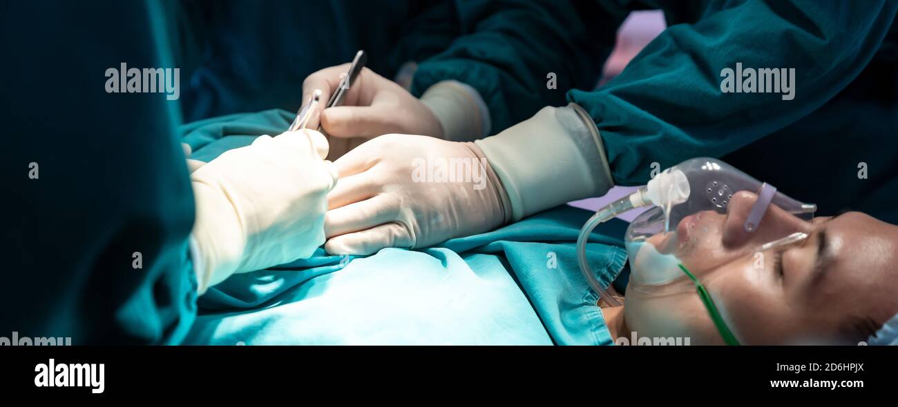 Panorama-Web-Banner Ernte Nahaufnahme Chirurg Arzt und Krankenschwester Durchführung chirurgische Operation zum Patienten mit seinem Team im Operationssaal ODER. Medizinische Gesundheit Stockfoto