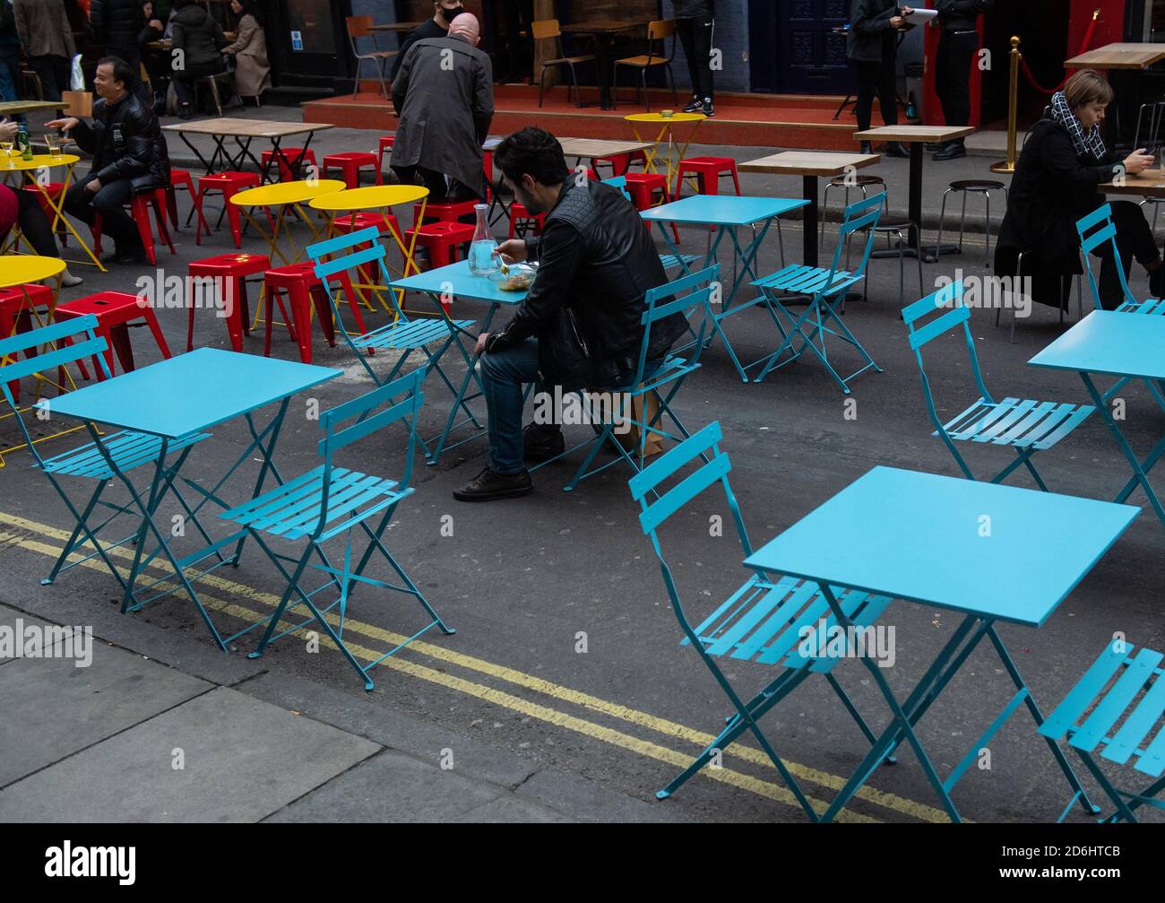 Menschen essen außerhalb Restaurants in Soho, London, am ersten Tag, nachdem die Stadt in Tier 2-Beschränkungen gesetzt wurde, um die Ausbreitung des Coronavirus einzudämmen. Stockfoto