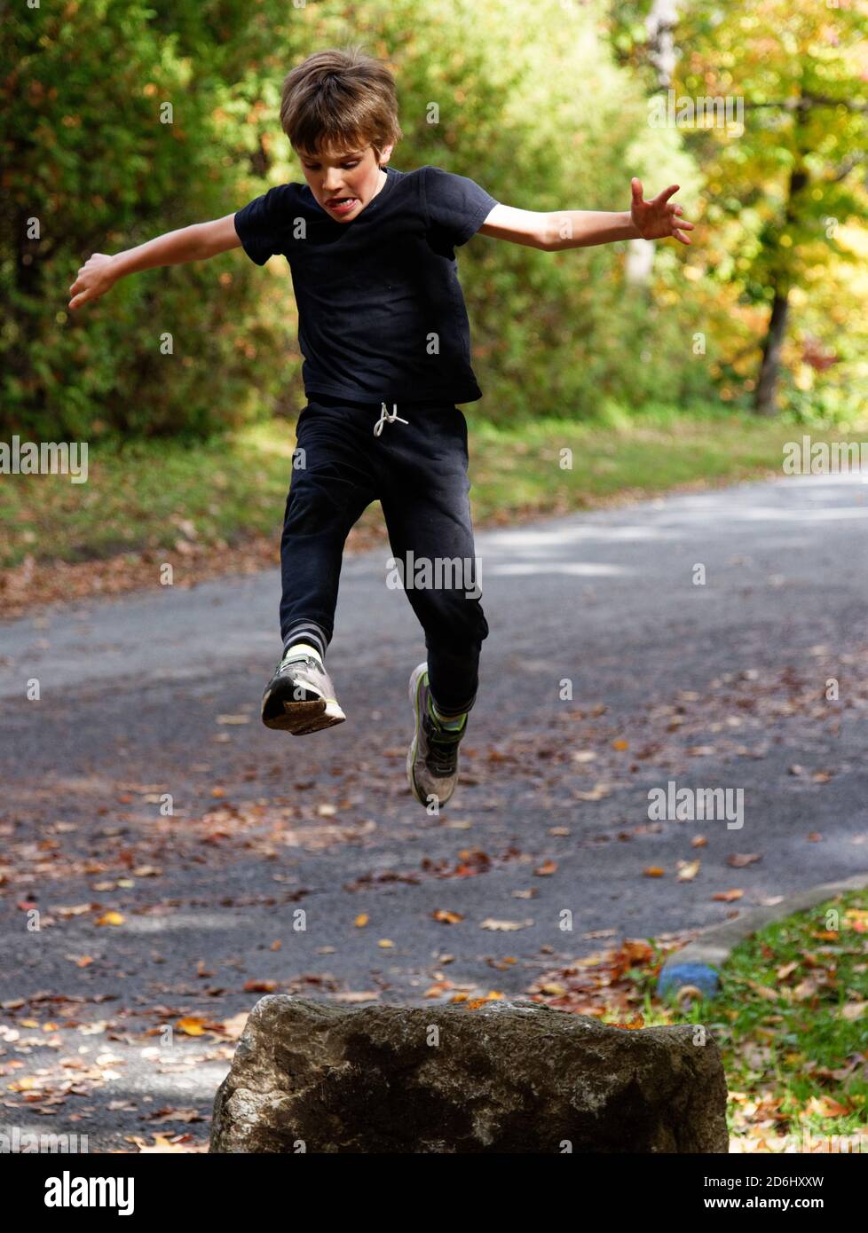 Ein athletischer 8-jähriger Junge, der hoch in die Sprünge Luft Stockfoto