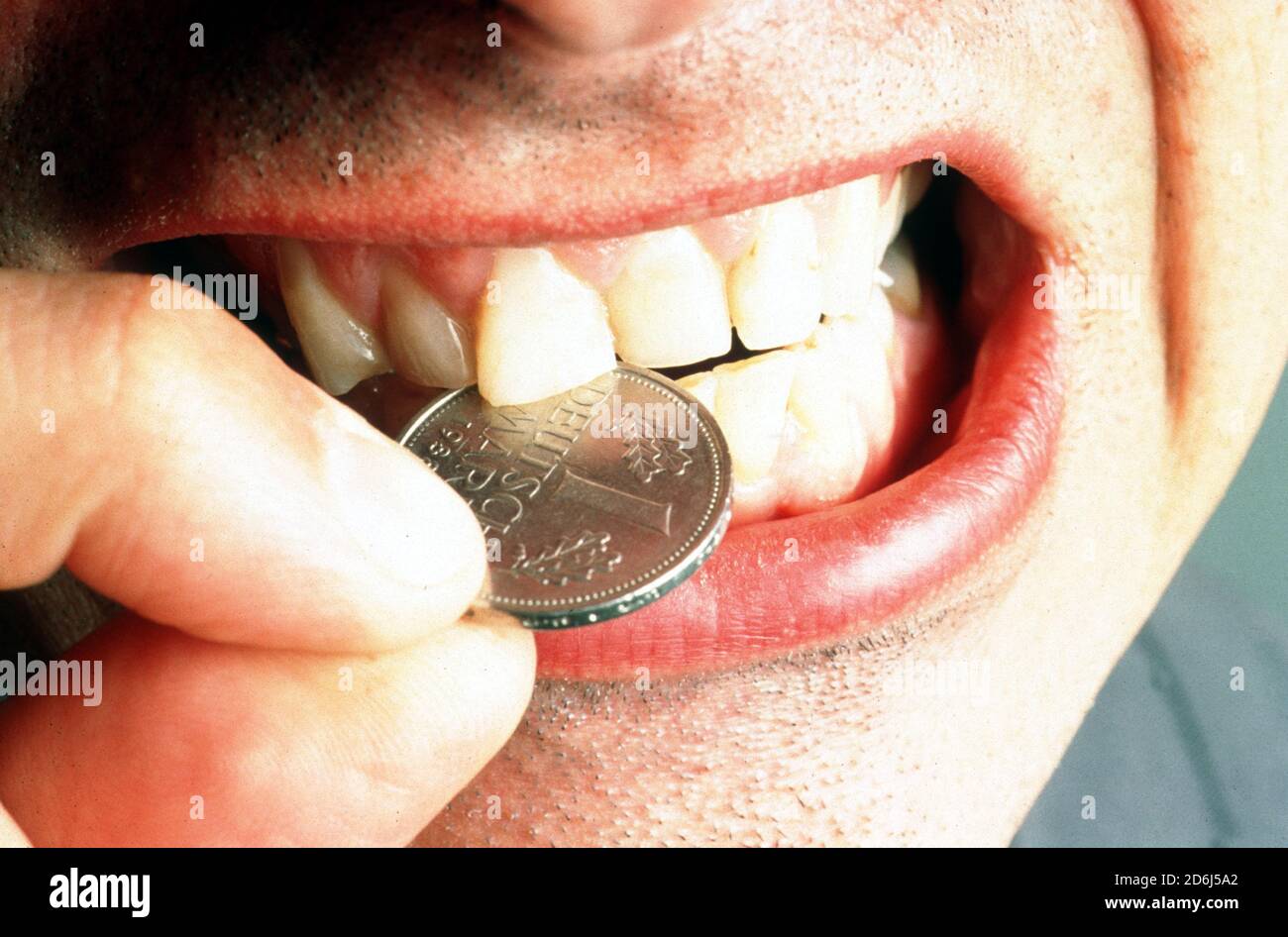 Die gute alte deutsche Mark, DM, harte Währung, Mann beißt in eine Münze, Berlin, Deutschland Stockfoto