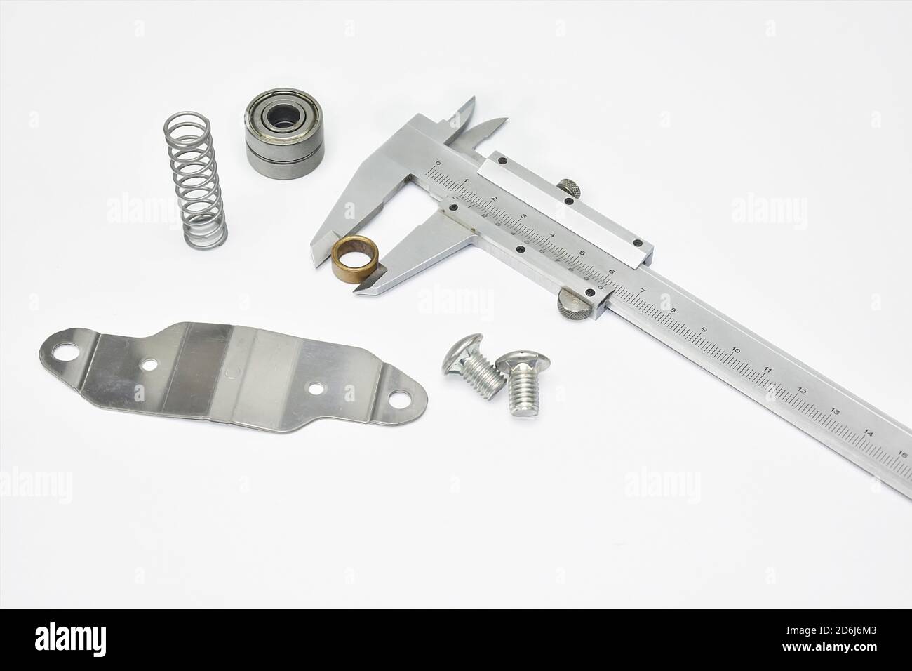 Messen technischer Materialien mit Messschieber. Messschieber, Metallfeder und Lager Ball isoliert Weißmetall Industrie Hintergrund Zusammensetzung Stockfoto