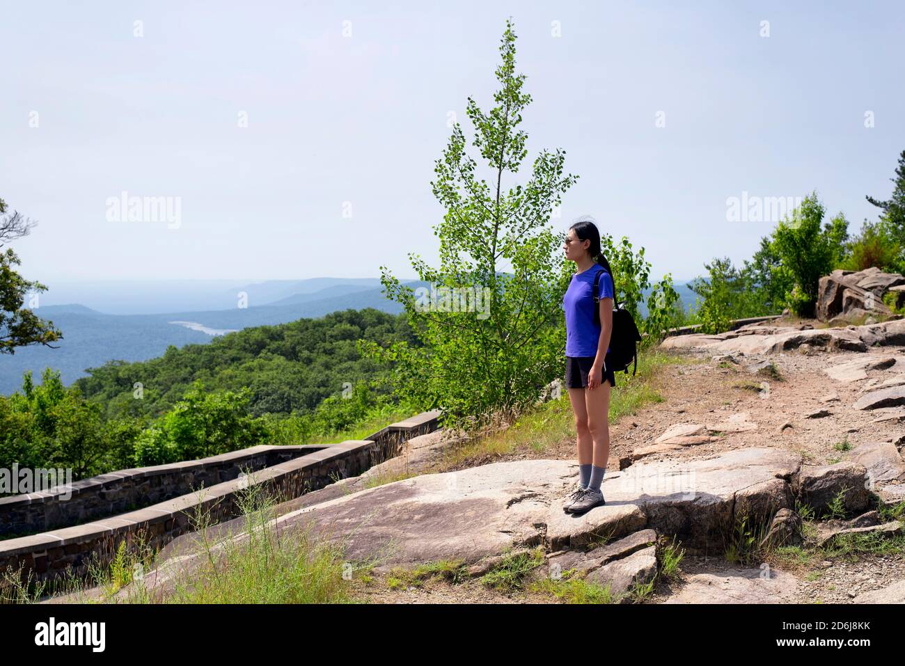 Eine chinesische Frau, die auf dem Aussichtberg im Lake george steht und die Landschaft überblickt. Stockfoto