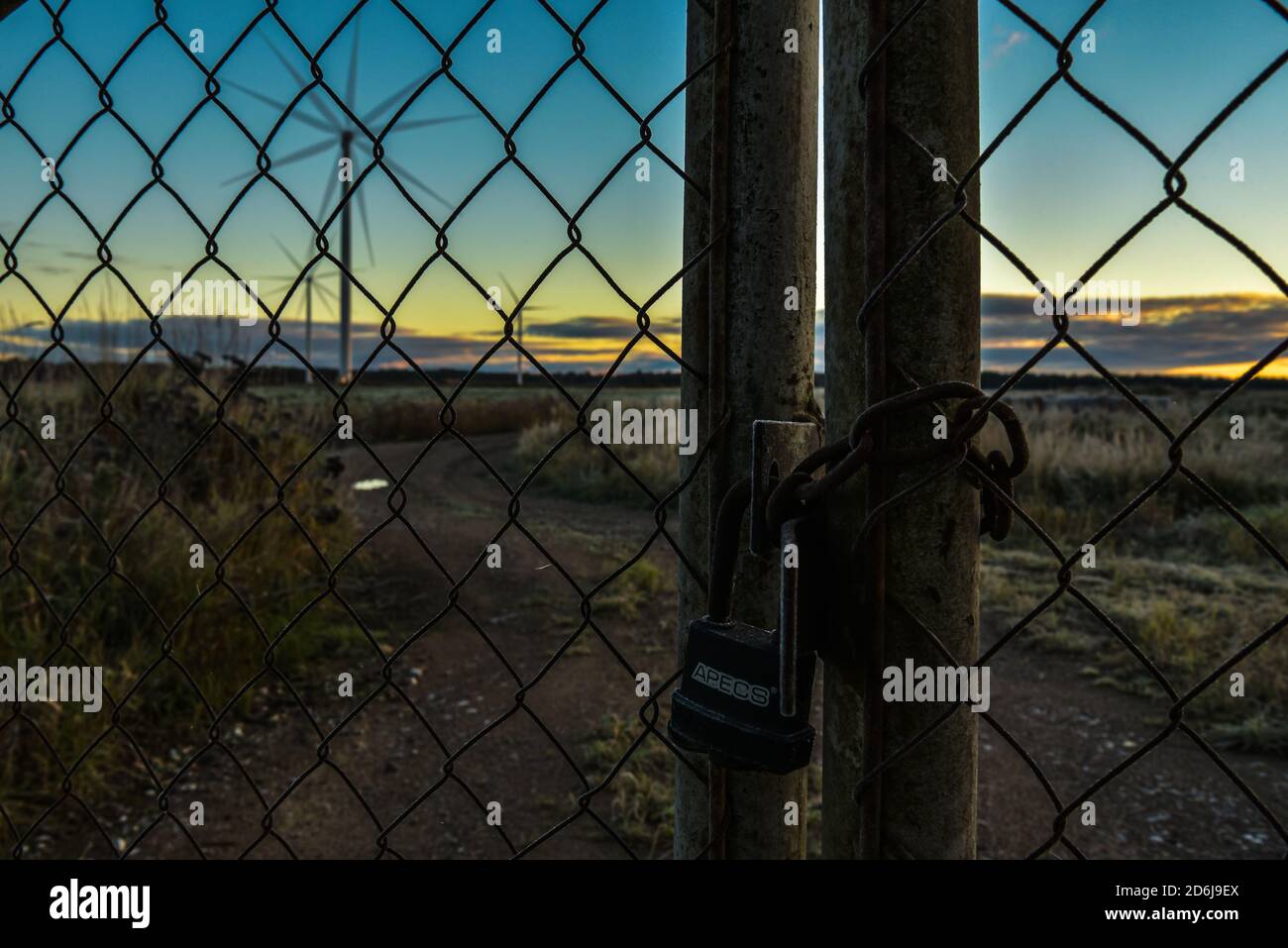 Straße mit geschlossenen Toren zu Windgeneratoren, die nicht Drehen Sie sich nicht mehr um, um umweltfreundlichen Strom zu erzeugen Stockfoto