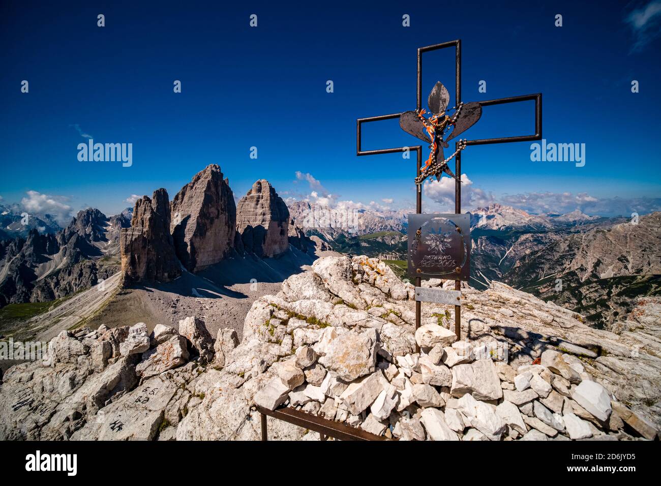 Ein Metallkreuz auf dem Gipfel von Paterno, Paternkofel, Dolomiti Landschaft und der Berggruppe Tre Cime di Lavaredo in der Ferne. Stockfoto