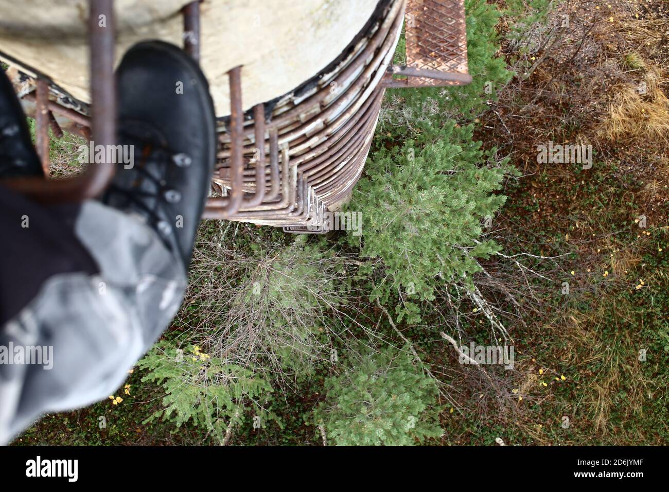 Blick von einer rostigen Leiter auf eine alte Betonsäule. Stockfoto