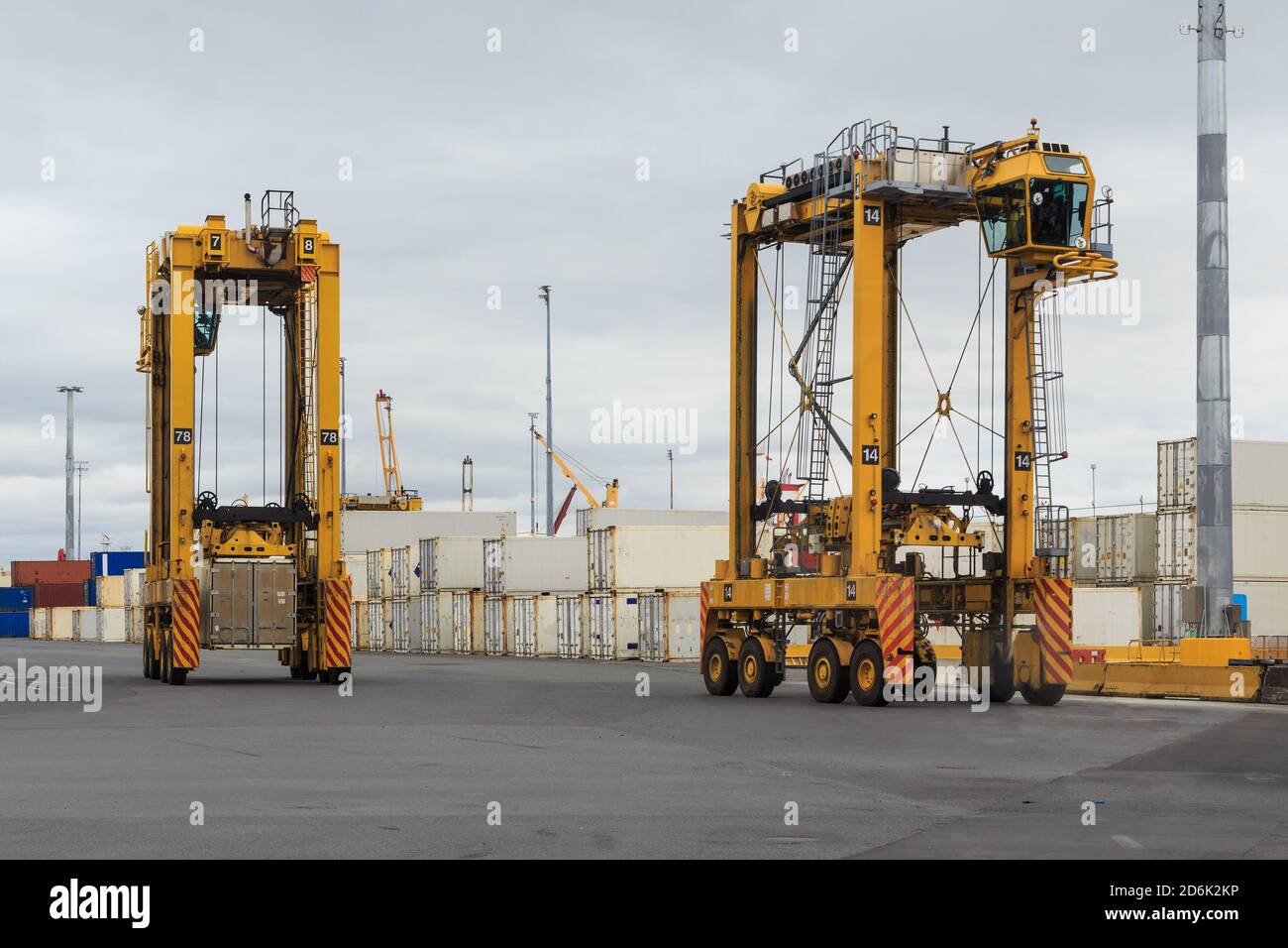 Zwei Straddle Carrier, riesige Fahrzeuge für den Transport von Frachtcontainern, an einem Hafen Stockfoto