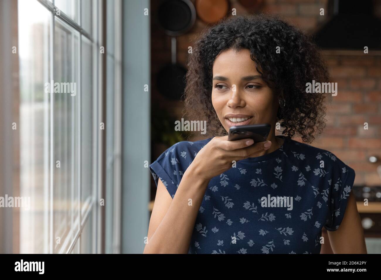 Afroamerikanische Frau aufzeichnen Sprachnachricht auf dem Smartphone Stockfoto