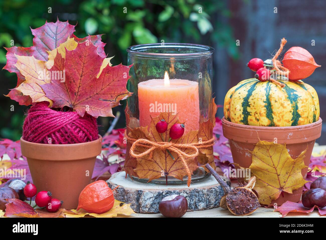 Rustikale Herbstdekoration mit oranger Kerze, Kürbis und Ahornblättern Stockfoto