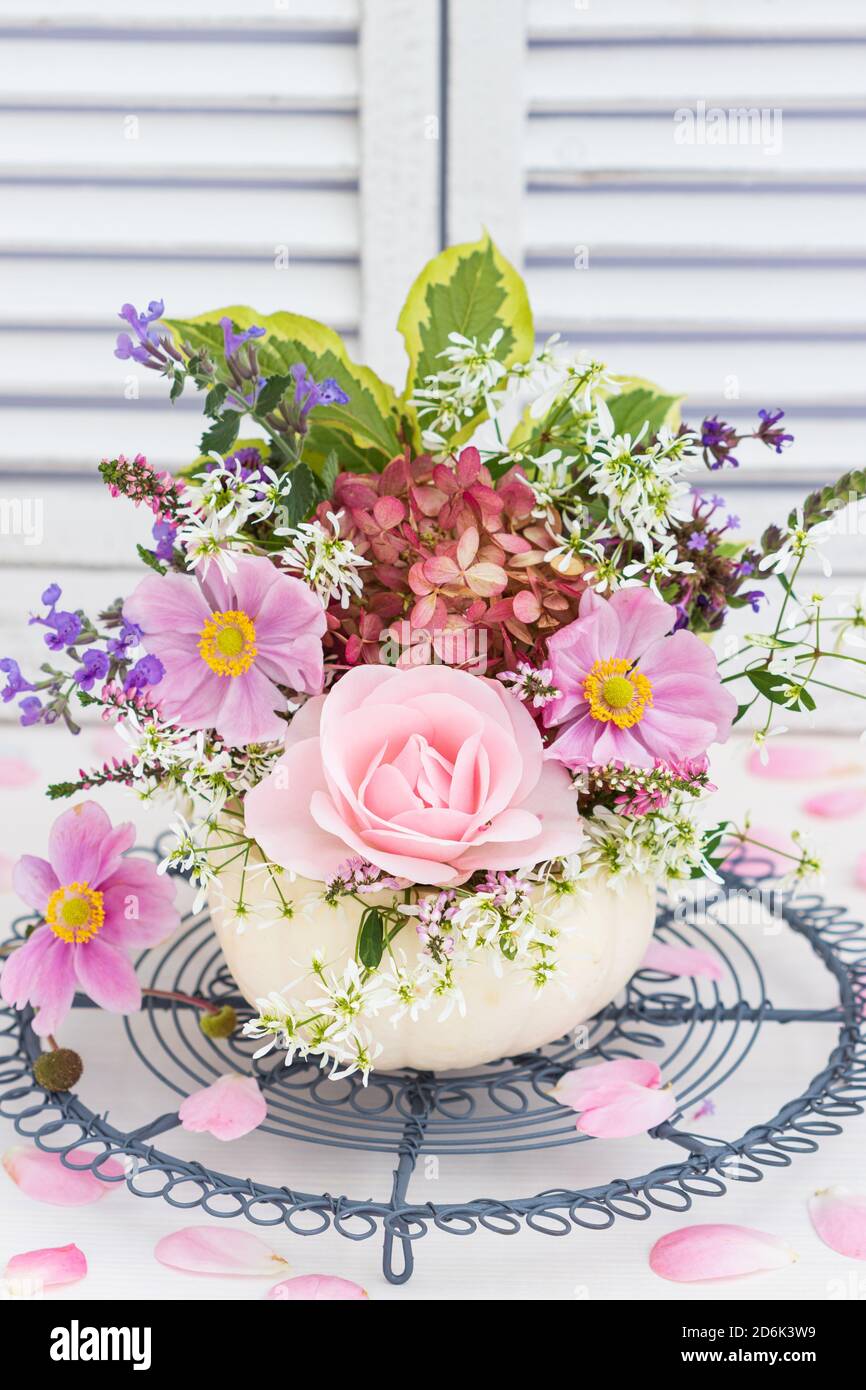 Romantisches Bouquet von Rose, japanischer Anemone und Hortensien in weißem Kürbis Stockfoto