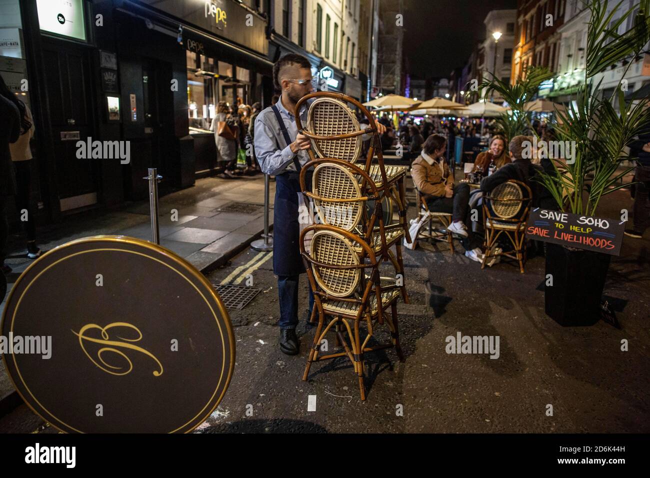 Ein Kellner auf der Old Compton Street packt Stühle und Tische vor Schließung um 22.00 Uhr während dessen, was als The Last Night of Freedom vor Tier 2 Lockdown wird auf Versammlungen in Restaurants und Bars in Soho, London, UK erzwungen Credit: Jeff Gilbert/Alamy Live News Stockfoto