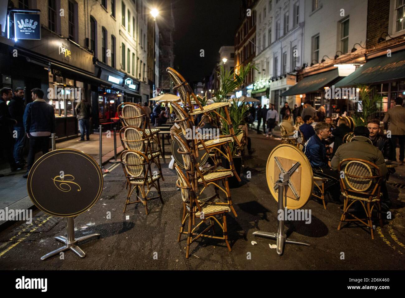 Ein Kellner auf der Old Compton Street packt Stühle und Tische vor Schließung um 22.00 Uhr während dessen, was als The Last Night of Freedom vor Tier 2 Lockdown wird auf Versammlungen in Restaurants und Bars in Soho, London, UK erzwungen Credit: Jeff Gilbert/Alamy Live News Stockfoto