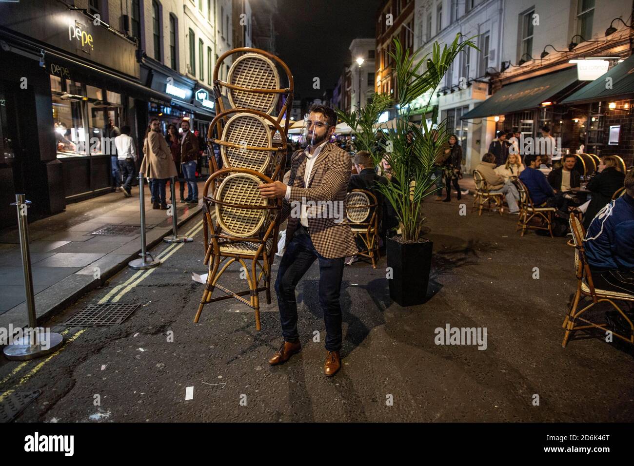 Ein Kellner auf der Old Compton Street packt Stühle und Tische vor Schließung um 22.00 Uhr während der Zeit, die als die letzte Nacht der Freiheit vor Tier 2 Lockdown wird auf Versammlungen in Restaurants und Bars in Soho, London, UK erzwungen Credit: Jeff Gilbert/Alamy Live News Stockfoto