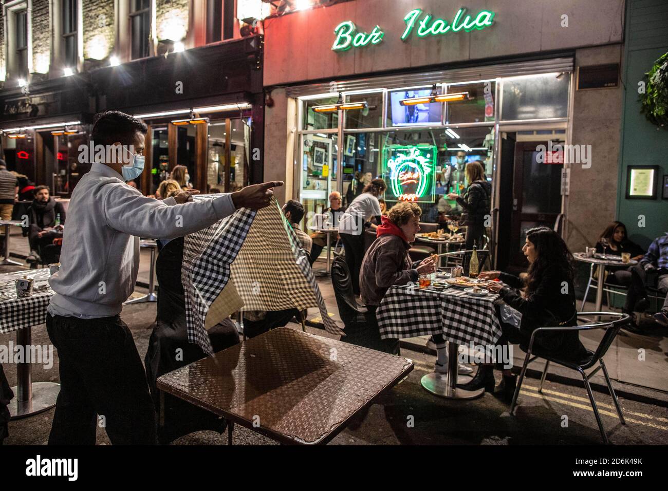 Ein Kellner auf der Old Compton Street packt Stühle und Tische vor Schließung um 22.00 Uhr während dessen, was als The Last Night of Freedom vor Tier 2 Lockdown wird auf Versammlungen in Restaurants und Bars in Soho, London, UK erzwungen Credit: Jeff Gilbert/Alamy Live News Stockfoto