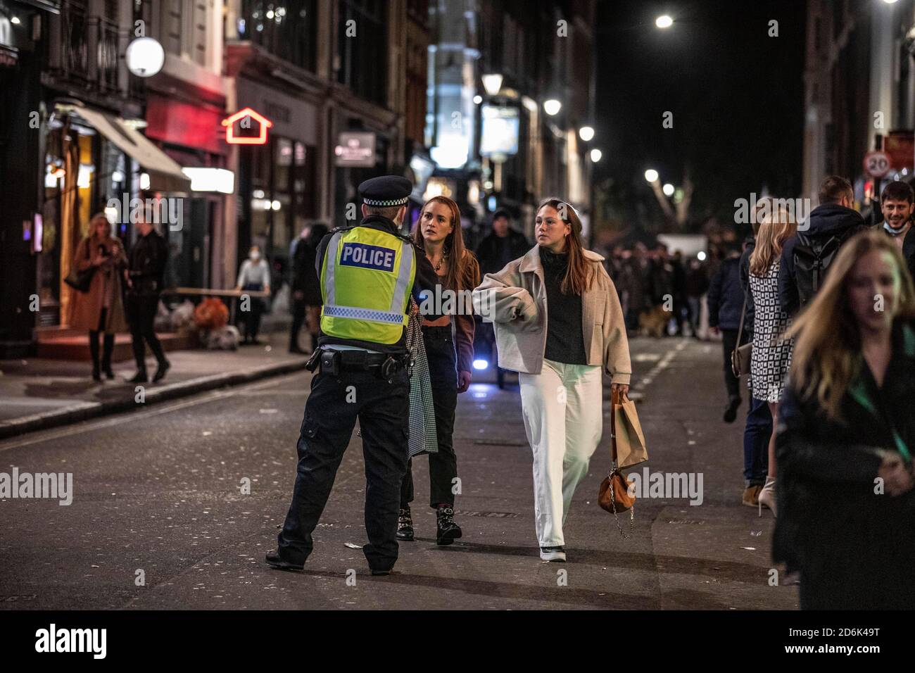 Ein paar junge Frauen werden von der Polizei abgewiesen, die auf der Old Compton Street patrouilliert, während das, was als die letzte Nacht der Freiheit als Stufe 2-Lockdown gilt, auf Versammlungen in Restaurants und Bars in Soho, London, Großbritannien erzwungen wird.Quelle: Jeff Gilbert/Alamy Live News Stockfoto