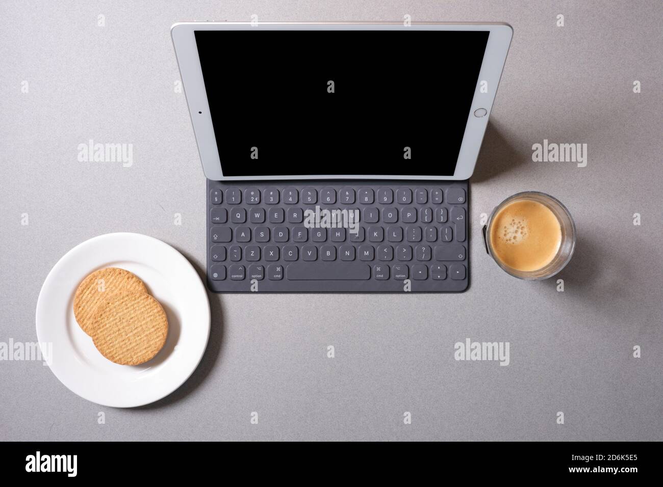 Arbeiten auf einem weißen ipad auf einem grauen Desktop mit Kaffee. Stockfoto