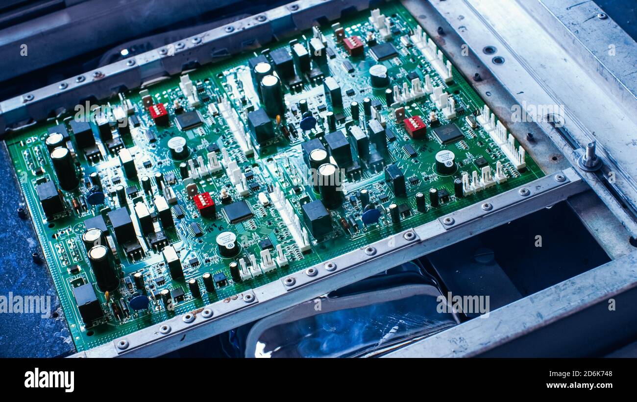 Elektronische Leiterplatte mit Mikrochips, Transistoren, Halbleitern, Kondensatoren Wasserkühlung Prozess auf der Montagelinie während Stockfoto