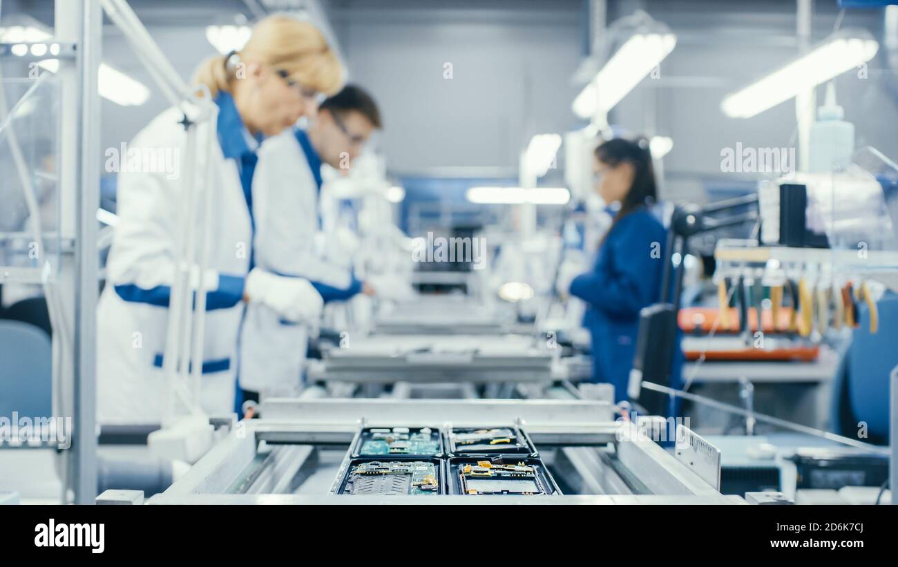Aufnahme eines Elektronikarbeiters, der Leiterplatten von Hand während der Montage auf der Montagelinie montieren kann. High-Tech-Fabrik. Stockfoto